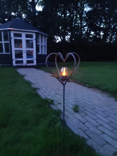 Hjerte i jern med lys i haven